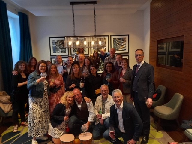 ALUMNI Former Pupils Assoc. Associates of the school in group photo holding drinks looking cheerful.