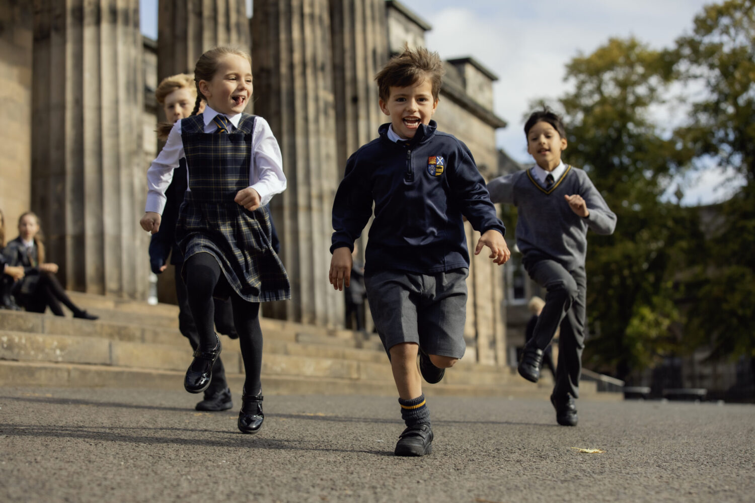 Home Page kids running. Young pupils running looking cheerful on play ground court yard running.