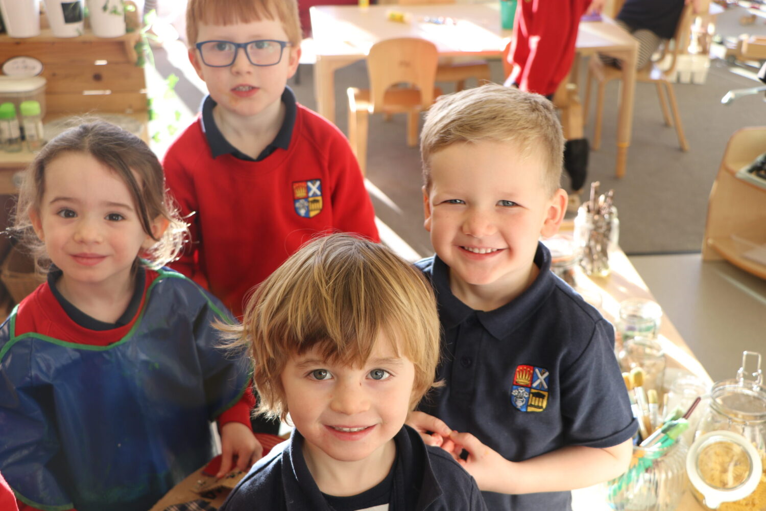 NURSERY HAPPY FACES. Nursery pupils taking a group photo in class looking cheerful.