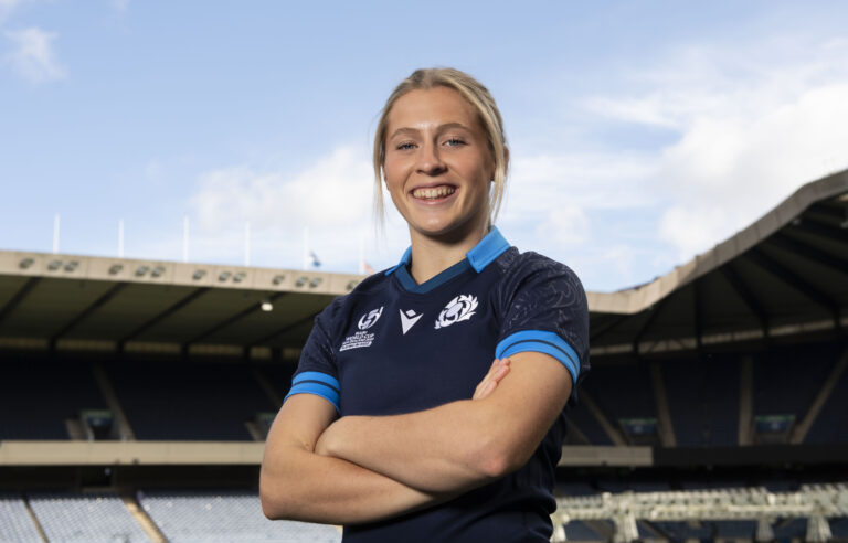 Shona Campbell. Shona Campbell professional rugby player posing with arms crossed smiling for photo in rugby stadium.