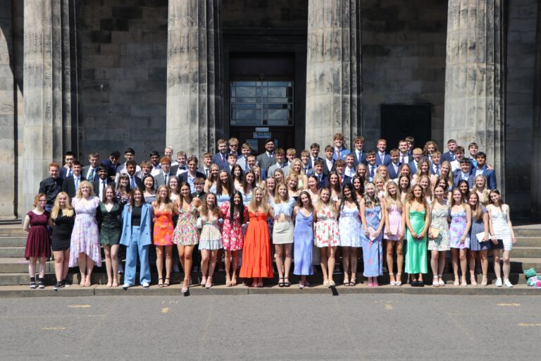 F6 Leavers. Leavers pupils dressed up in smart clothing in group photo, outside of the front of school building on steps.