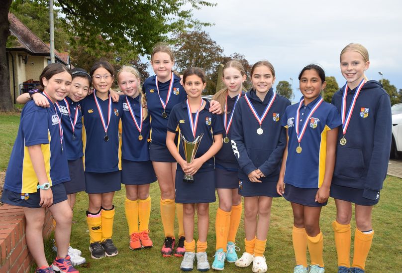 Goals And Tries Galore At HSD P7 Hockey And Rugby Festival featured. Pupils posing with awards of trophy and medals around their necks. All posing in line .