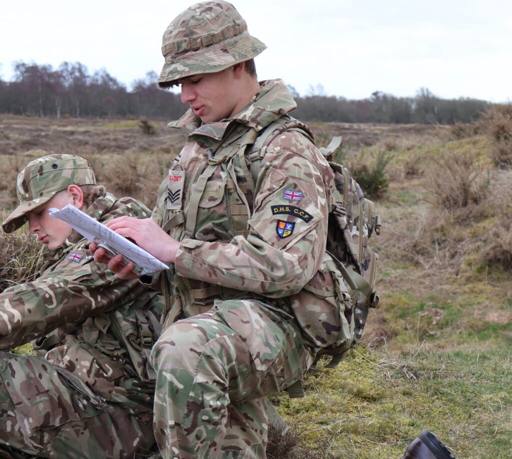 An HSD cadet reads map in the field
